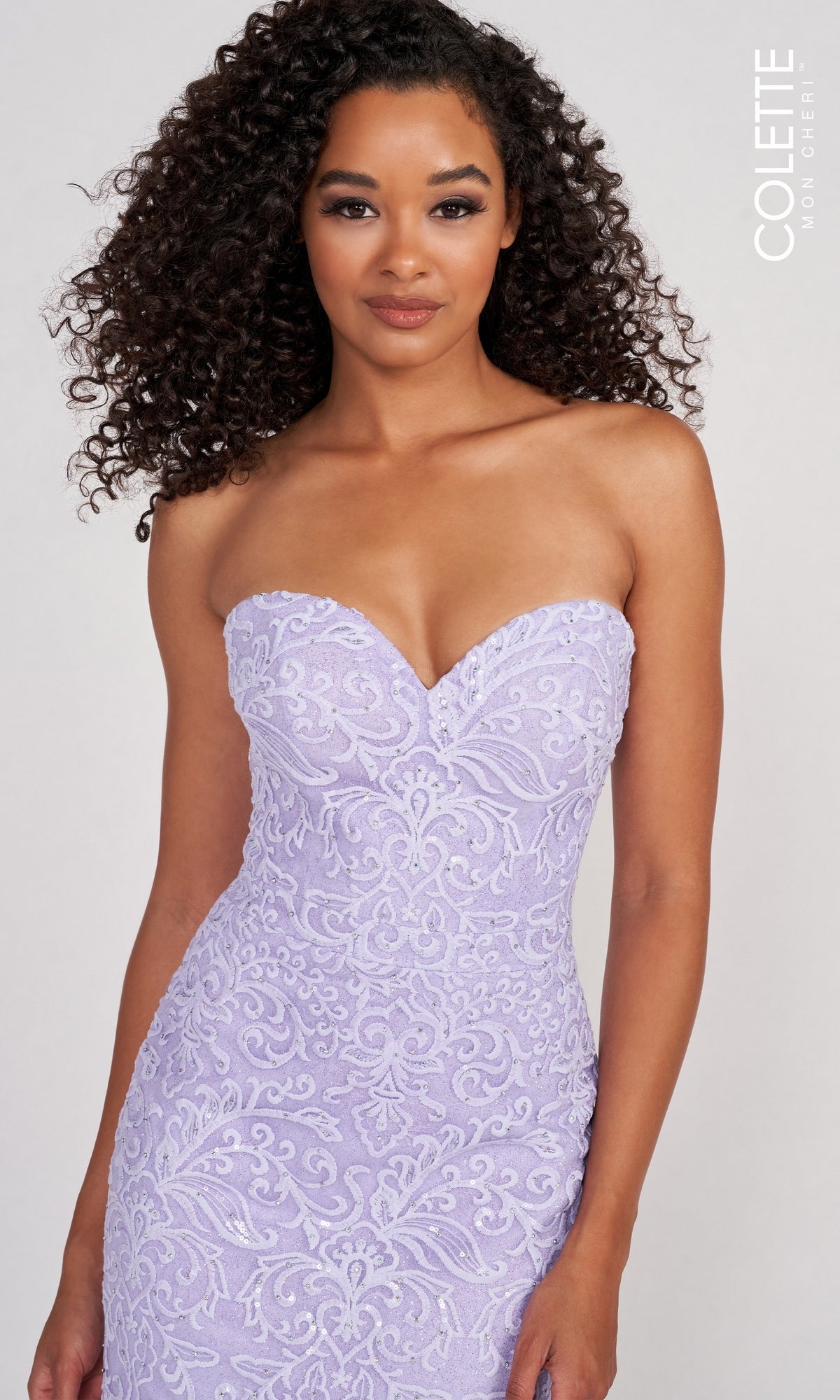 A woman stands against a plain background wearing the Colette Pastel Strapless Lace Mermaid Prom Dress, featuring a sweetheart neckline, ornate embroidery, and a fitted silhouette for an elegant, timeless look.